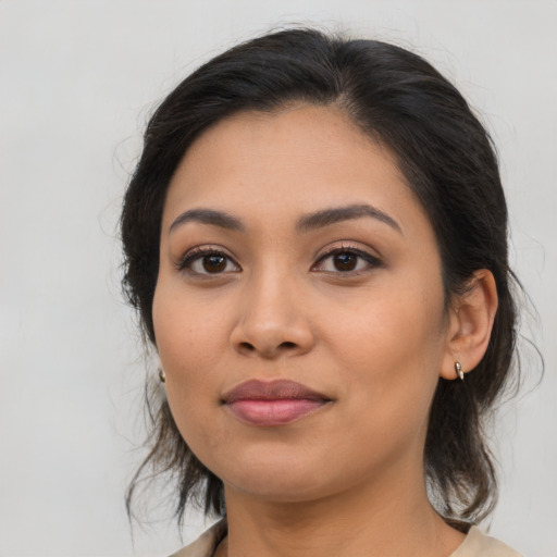 Joyful latino young-adult female with medium  brown hair and brown eyes