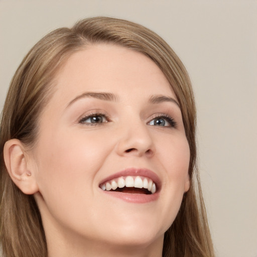 Joyful white young-adult female with long  brown hair and grey eyes