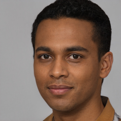 Joyful black young-adult male with short  black hair and brown eyes