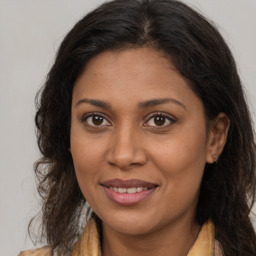 Joyful black young-adult female with long  brown hair and brown eyes