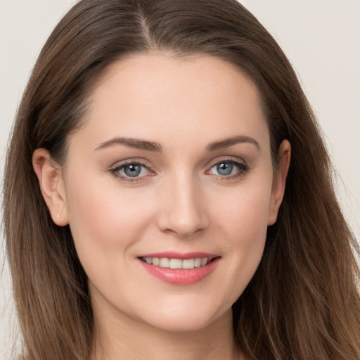 Joyful white young-adult female with long  brown hair and grey eyes