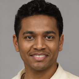 Joyful latino young-adult male with short  black hair and brown eyes