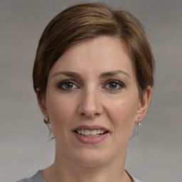 Joyful white young-adult female with medium  brown hair and grey eyes