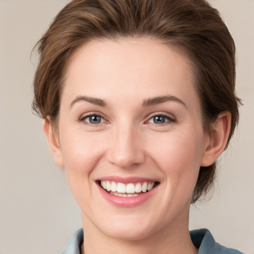 Joyful white young-adult female with medium  brown hair and grey eyes