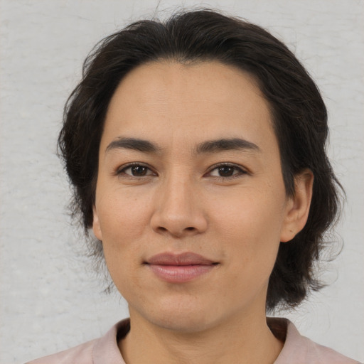 Joyful asian adult female with medium  brown hair and brown eyes