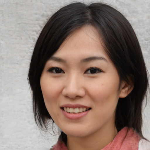 Joyful asian young-adult female with medium  black hair and brown eyes