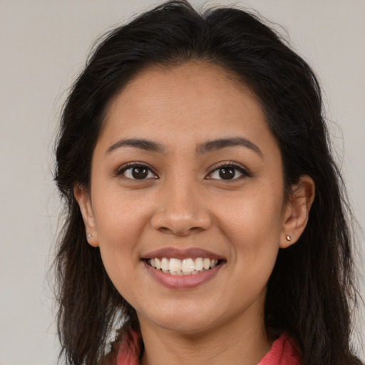 Joyful latino young-adult female with long  brown hair and brown eyes