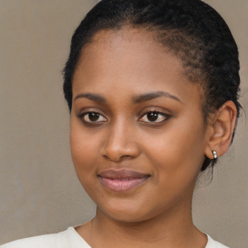 Joyful black young-adult female with short  black hair and brown eyes