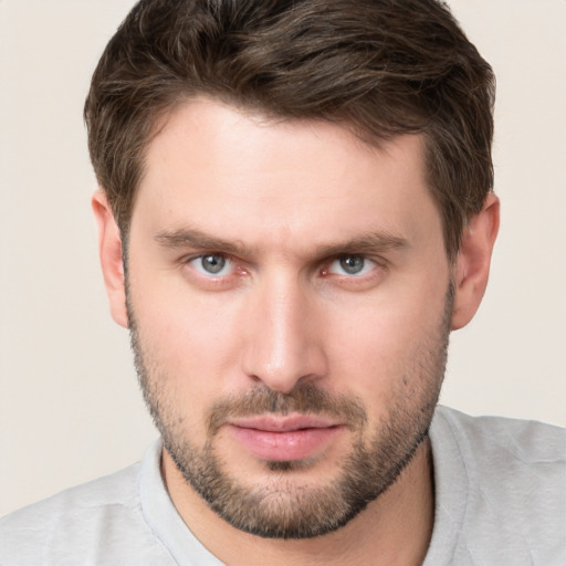 Joyful white young-adult male with short  brown hair and grey eyes