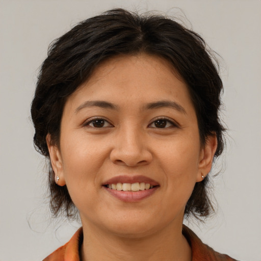 Joyful asian adult female with medium  brown hair and brown eyes