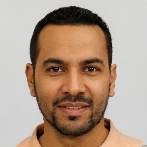 Joyful latino young-adult male with short  black hair and brown eyes