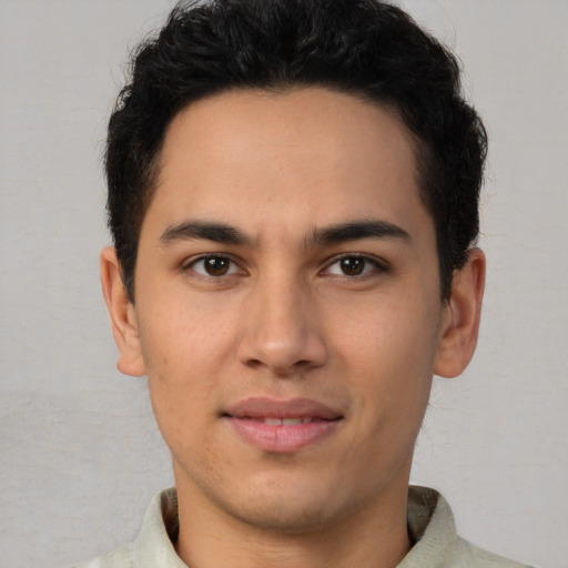 Joyful latino young-adult male with short  brown hair and brown eyes