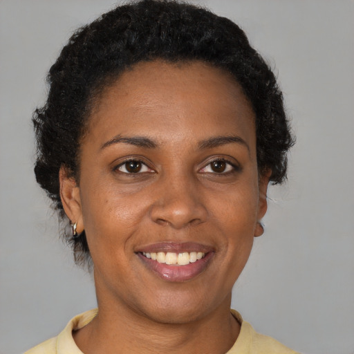 Joyful black young-adult female with short  brown hair and brown eyes