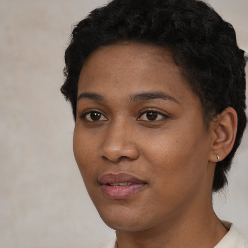 Joyful black young-adult female with short  black hair and brown eyes