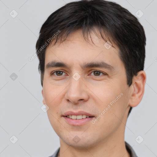 Joyful white young-adult male with short  black hair and brown eyes