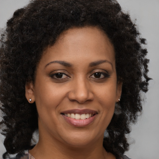 Joyful black young-adult female with medium  brown hair and brown eyes