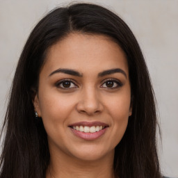 Joyful latino young-adult female with long  brown hair and brown eyes