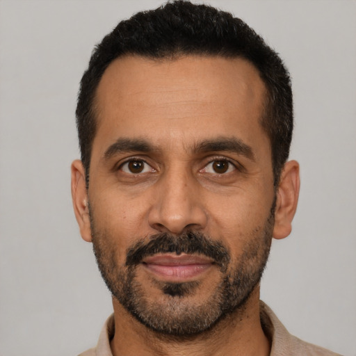 Joyful black adult male with short  black hair and brown eyes