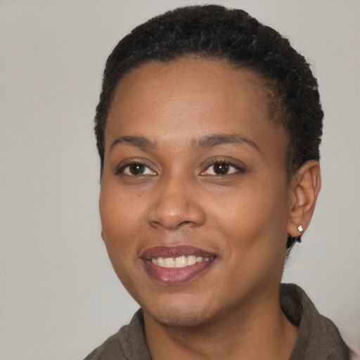 Joyful black young-adult female with short  brown hair and brown eyes