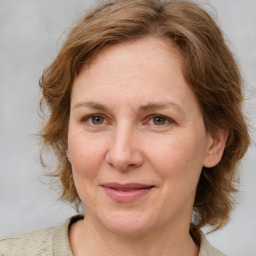 Joyful white adult female with medium  brown hair and blue eyes