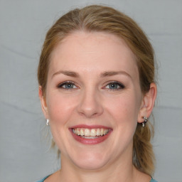 Joyful white young-adult female with medium  brown hair and blue eyes