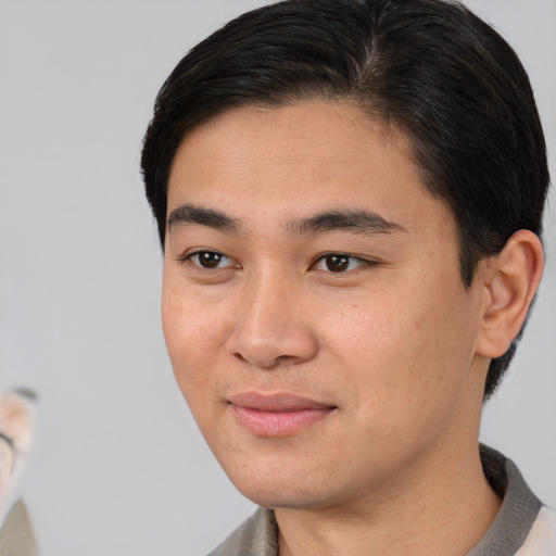 Joyful asian young-adult male with short  black hair and brown eyes