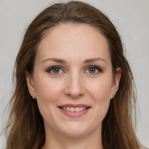 Joyful white young-adult female with long  brown hair and grey eyes