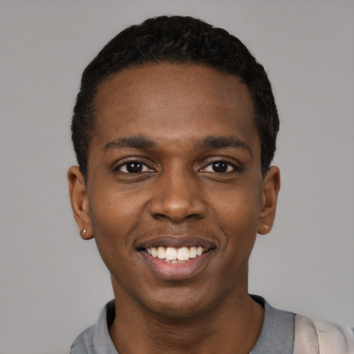 Joyful black young-adult male with short  black hair and brown eyes