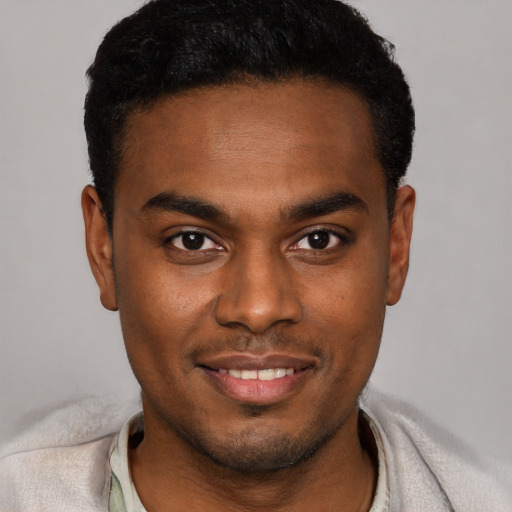 Joyful black young-adult male with short  black hair and brown eyes