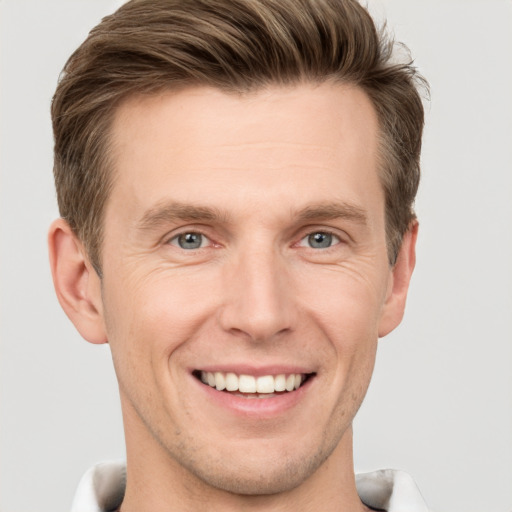 Joyful white adult male with short  brown hair and grey eyes