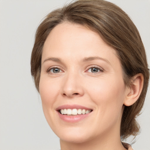 Joyful white young-adult female with medium  brown hair and green eyes