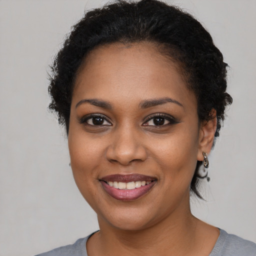 Joyful black young-adult female with short  black hair and brown eyes