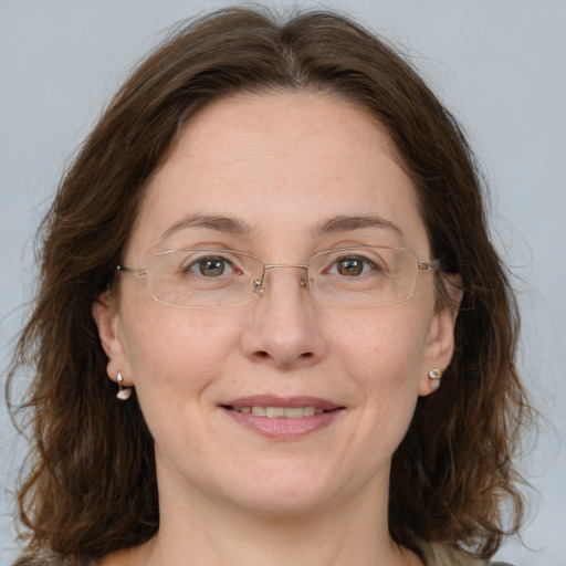 Joyful white adult female with medium  brown hair and green eyes