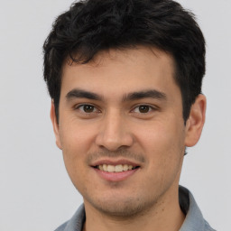 Joyful latino young-adult male with short  brown hair and brown eyes