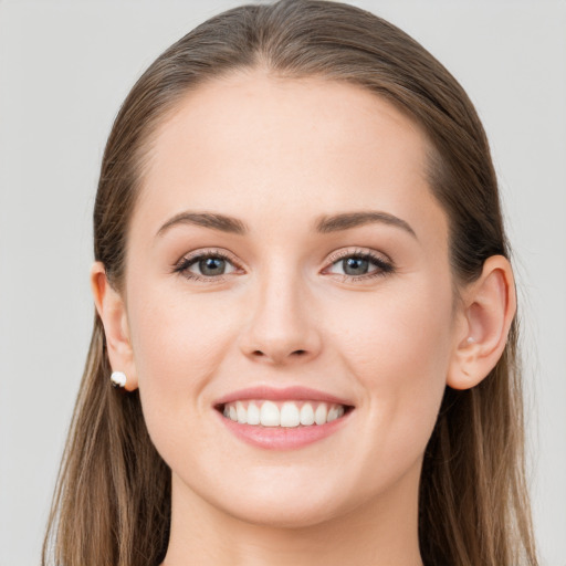 Joyful white young-adult female with long  brown hair and grey eyes