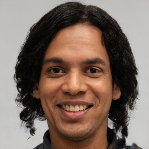 Joyful latino young-adult male with medium  black hair and brown eyes