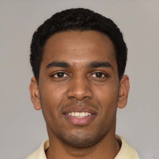 Joyful black young-adult male with short  black hair and brown eyes