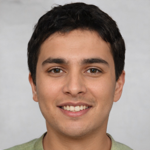Joyful white young-adult male with short  black hair and brown eyes