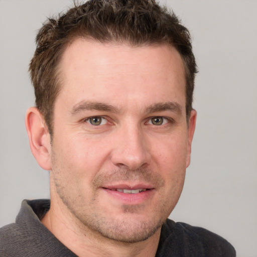 Joyful white adult male with short  brown hair and grey eyes