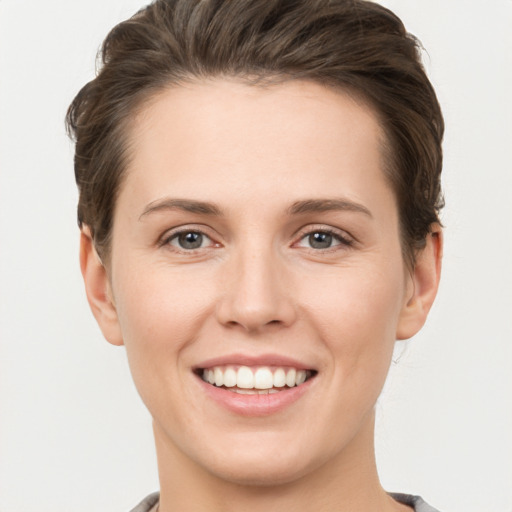 Joyful white young-adult female with short  brown hair and grey eyes