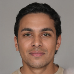 Joyful latino young-adult male with short  brown hair and brown eyes