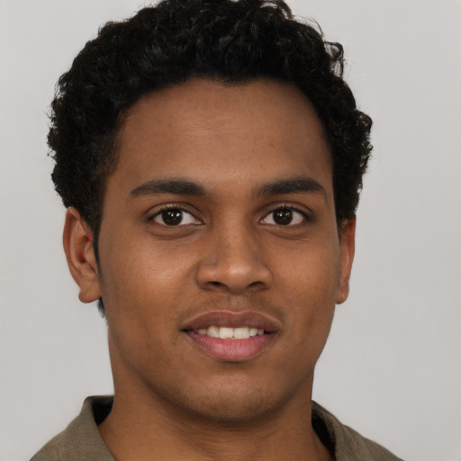 Joyful black young-adult male with short  brown hair and brown eyes