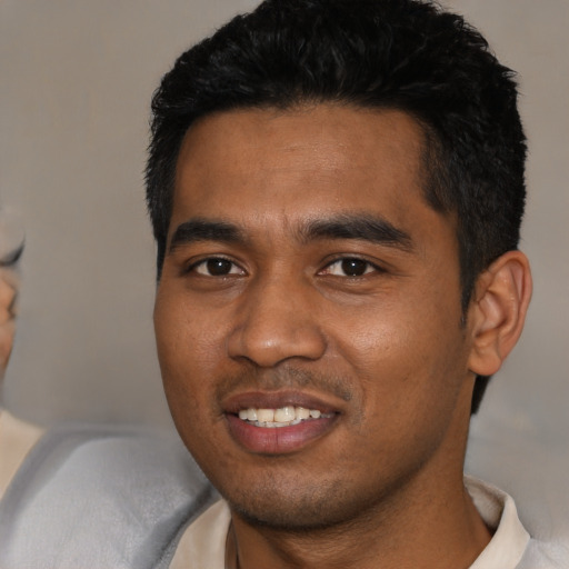 Joyful black young-adult male with short  black hair and brown eyes