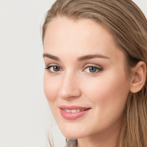 Joyful white young-adult female with long  brown hair and grey eyes