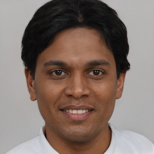 Joyful black young-adult male with short  brown hair and brown eyes