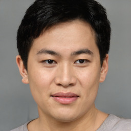 Joyful asian young-adult male with short  brown hair and brown eyes