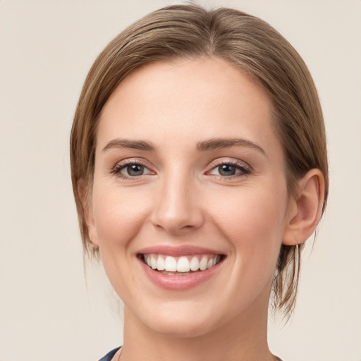 Joyful white young-adult female with medium  brown hair and grey eyes