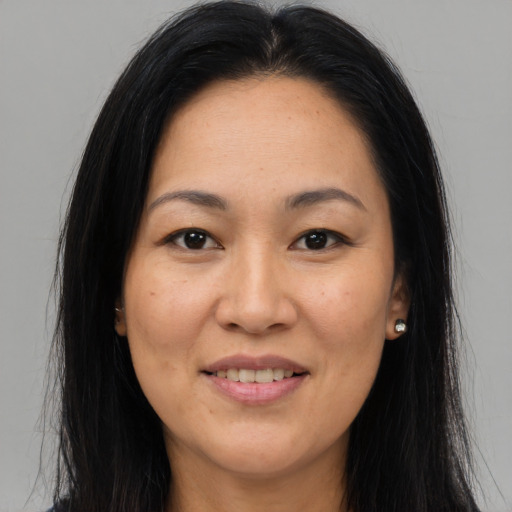 Joyful asian adult female with long  brown hair and brown eyes