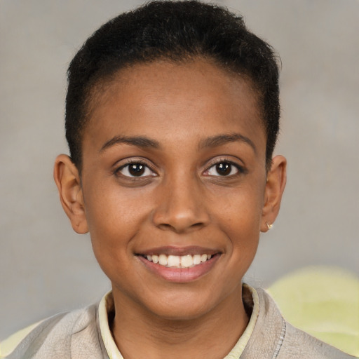 Joyful black young-adult female with short  brown hair and brown eyes