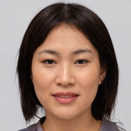 Joyful asian young-adult female with medium  brown hair and brown eyes